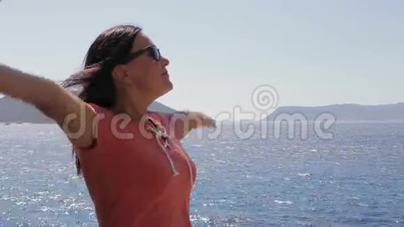 美丽的女人享受阳光和大海视频的预览图