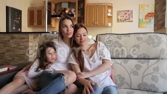 两个姐妹和一个小女孩在沙发上的肖像视频的预览图