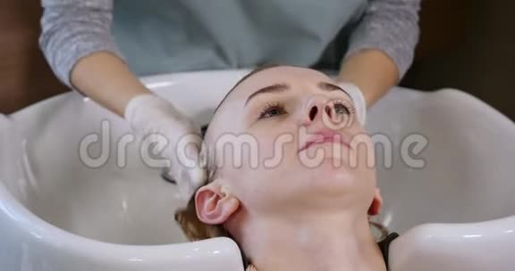 现代水疗中心的头发护理理发店理发的女人女人在水疗中心洗头水疗中心视频的预览图