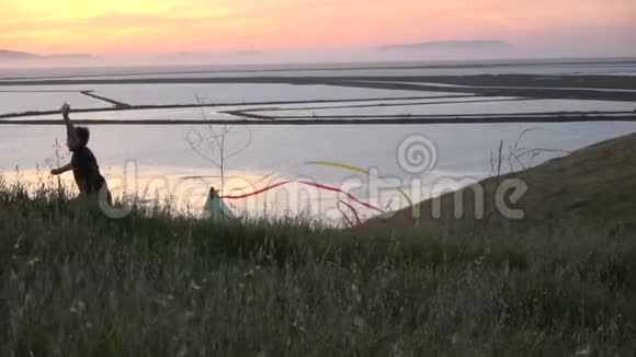 日落时放风筝的男孩剪影视频的预览图