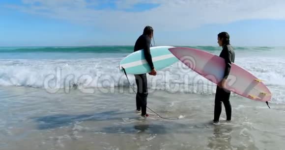 冲浪者夫妇和冲浪板站在海上4k视频的预览图