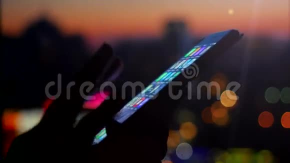 女人用她的手机在美丽模糊的城市背景与博克4k视频的预览图