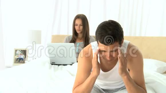 不高兴的男人在妻子用笔记本电脑工作的时候视频的预览图