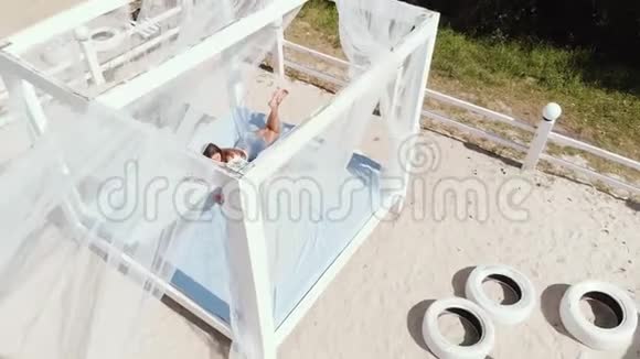 精致的女孩和她的小女儿在海滩上的平房里放松和玩耍视频的预览图