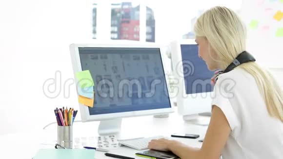 可爱的女创意设计师在她的电脑上工作视频的预览图