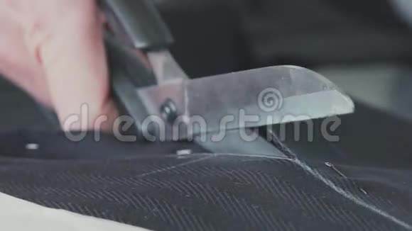 裁缝手拿着布料用剪刀剪视频的预览图