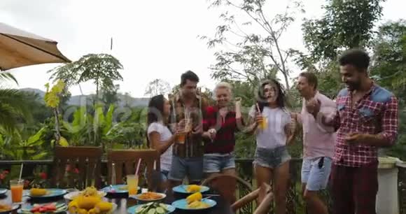 青少年跳舞烹饪烧烤之友小组在夏日露台聚会视频的预览图