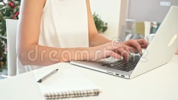 在笔记本电脑上工作的年轻女人的特写慢动作视频的预览图