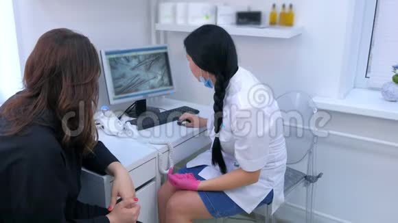 旋毛医师在临床上使用计算机旋毛镜检查女性病人的毛发视频的预览图