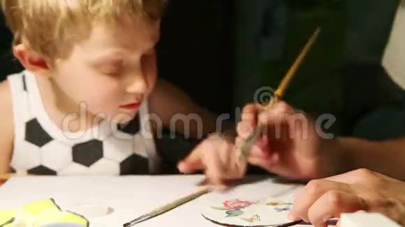 母亲带着小儿子的油漆手工制作饮料杯视频的预览图