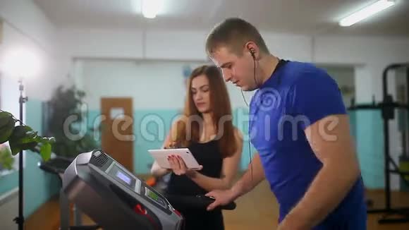 男人在跑步机上运动女孩在跑步机上训练运动健康的生活方式视频的预览图