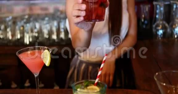酒吧柜台供应鸡尾酒的酒吧服务员画像视频的预览图