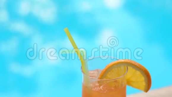 泳池背景的橙色鸡尾酒特写视频的预览图