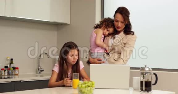 微笑着工作的母亲和她的孩子吃早餐视频的预览图