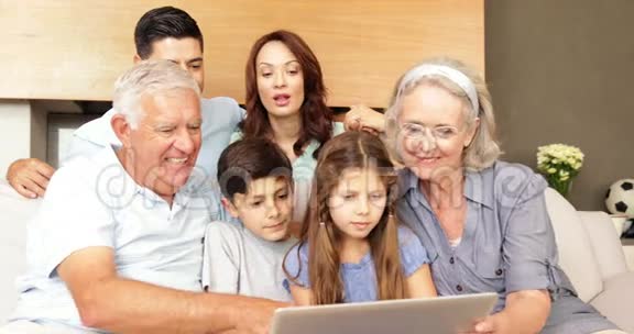 幸福的大家庭一起在沙发上用笔记本电脑视频的预览图