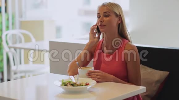有咖啡电话智能手机的女士视频的预览图