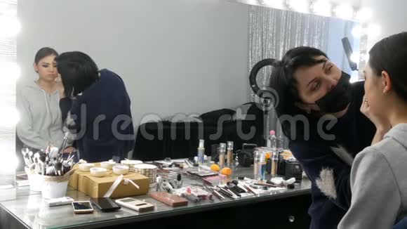 专业造型师化妆师在视觉工作室里为一个亚洲女孩化妆视频的预览图