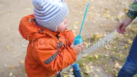 公园里一个快乐的小孩在吹肥皂泡视频的预览图