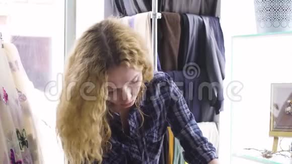 年轻漂亮的女人在纺织店挑选布料视频的预览图