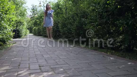 美丽的女人在夏天的公园里带着浪漫的心情散步视频的预览图