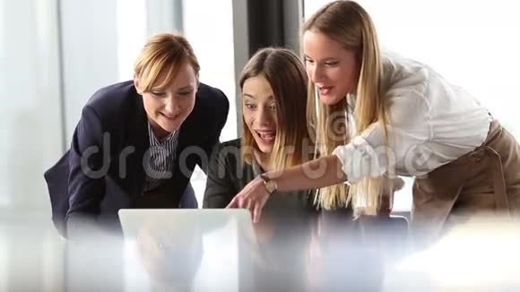 三位漂亮的商务女性在办公室会议上欢呼雀跃视频的预览图
