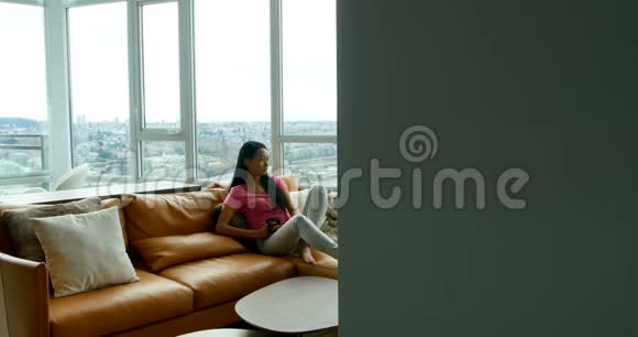 体贴的女人在客厅里喝咖啡视频的预览图