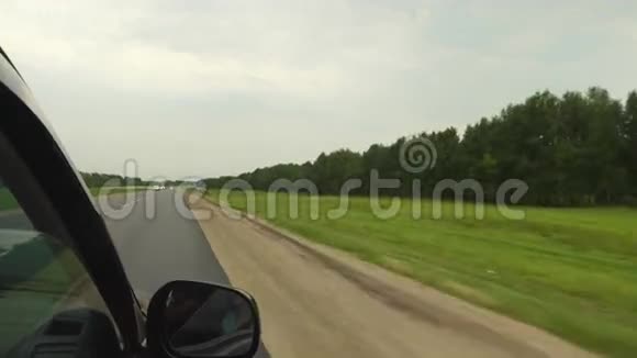 车正沿着森林的道路行驶视频的预览图