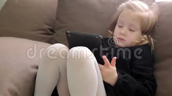 小可爱坐在沙发上玩平板电脑视频的预览图