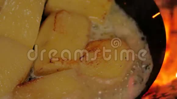 在露天篝火上用碳钢煎锅煎炸黄油土豆视频的预览图