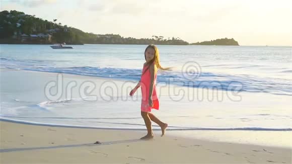可爱的活跃的小女孩在白色海滩日落流动人口视频的预览图
