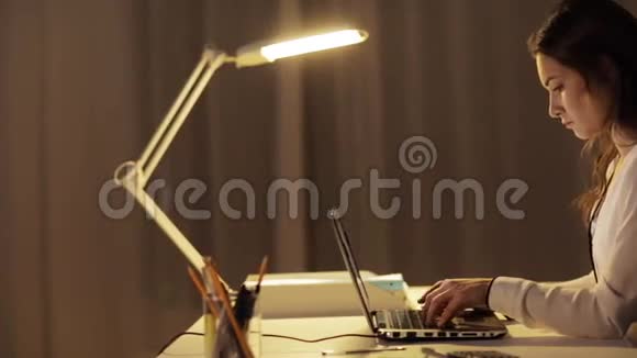疲惫的女人在夜间办公室打手提电脑视频的预览图