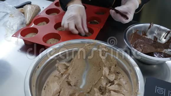 一个糖果师用巧克力填充硅饼模具视频的预览图