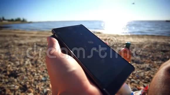 人类的双手在海边使用移动智能手机视频的预览图