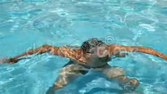 一个人用蓝色的水潜入游泳池溅向不同的方向飞行慢动作视频的预览图