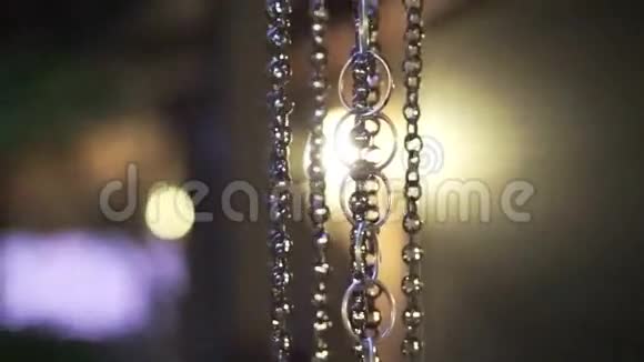 视频水滴落在金属链上雨水顺着亚洲壶的链接用夜光模糊收集水视频的预览图
