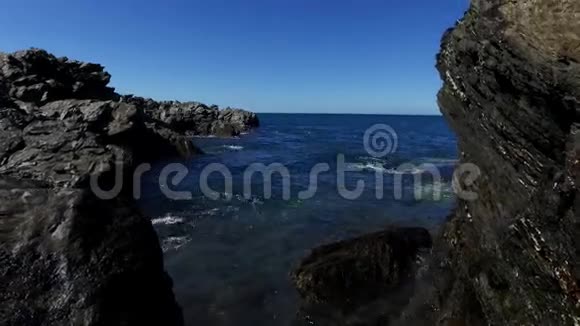 潮水带着地平线轻轻地从海岸岩石上涌进来视频的预览图