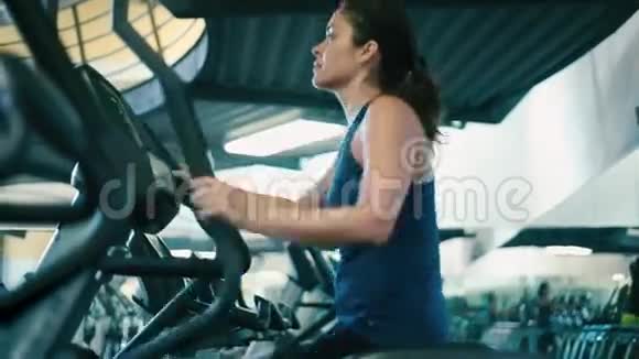 在健身房锻炼椭圆机的女人视频的预览图