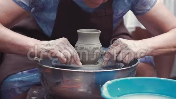 带着孙子孙女的祖母在陶器里做陶器视频的预览图