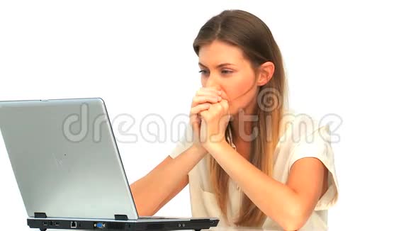 悲伤的女人看着她的笔记本电脑视频的预览图
