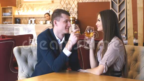 微笑的情侣在餐厅吃晚饭喝白葡萄酒视频的预览图