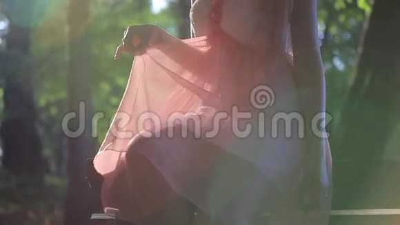 穿着粉色裙子坐在长凳上的女孩视频的预览图