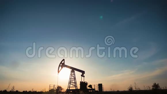日落时油田工作油泵剪影工业设备视频的预览图
