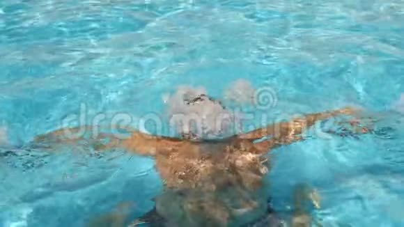 一个人用蓝色的水潜入游泳池溅向不同的方向飞行慢动作视频的预览图