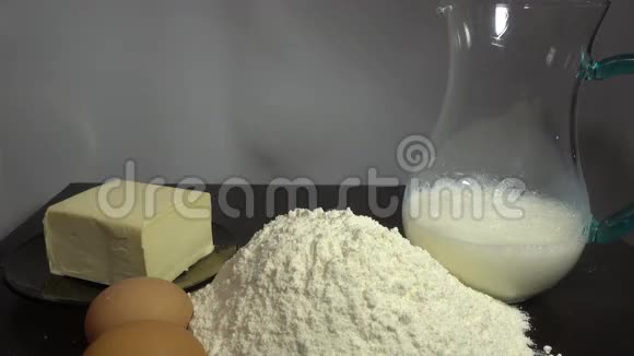 木制桌子上有小麦面粉牛奶鸡蛋和黄油接近高清视频的预览图