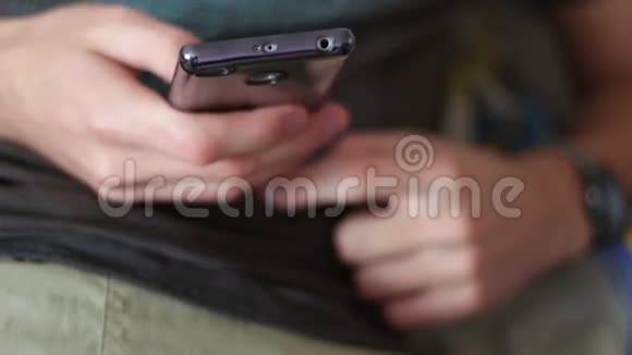 年轻人躺在沙发上拿着智能手机打印一条信息视频的预览图