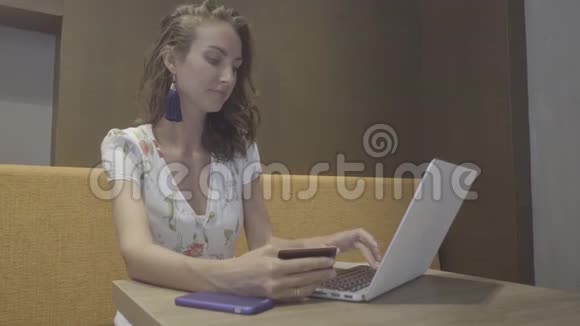 网上购物有笔记本电脑和信用卡的女人视频的预览图