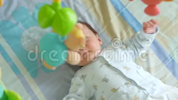 婴儿在婴儿床上玩手机视频的预览图
