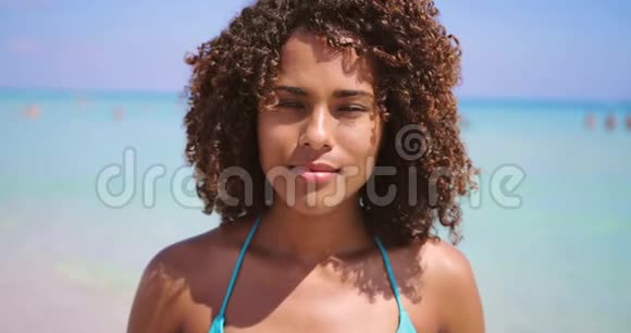 微笑着站在海滩上的少数民族妇女视频的预览图