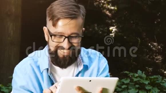 帅哥在平板电脑上冲浪微笑视频的预览图