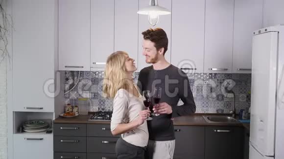年轻夫妇在家里的厨房里喝红酒视频的预览图